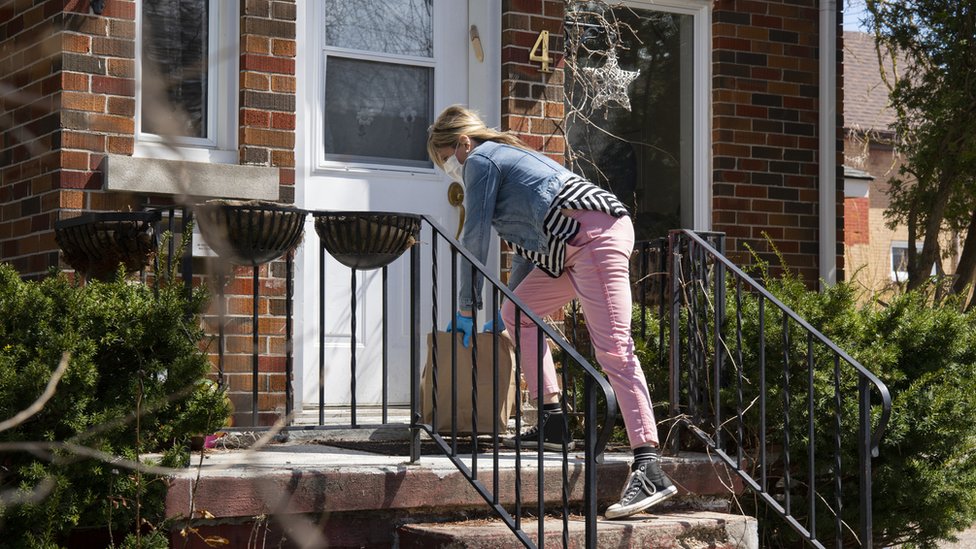 A woman placing food outside a home