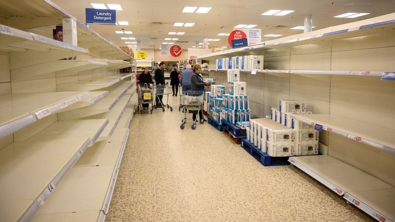 Shoppers peruse near-empty toilet roll shelves at a supermarket in the centre of York, northern England, on March 19, 2020. - Britain's supermarkets on Wednesday stepped up efforts to safeguard supplies, especially for vulnerable and elderly customers, as the sector battles stockpiling caused by coronavirus panic. (Photo by OLI SCARFF / AFP) (Photo by OLI SCARFF/AFP via Getty Images)