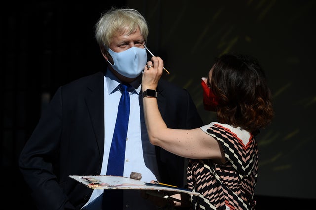 An artist puts the finishing touches to a wax figure of Prime Minister Boris Johnson, in the entrance line at Madame Tussaud's in London, as the attraction prepares to reopen to the public following the easing of lockdown restrictions in England