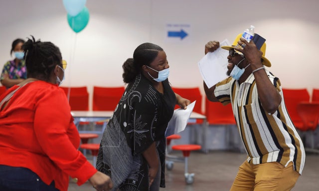 Parents and a student react after checking GCSE results at Ark Academy in London