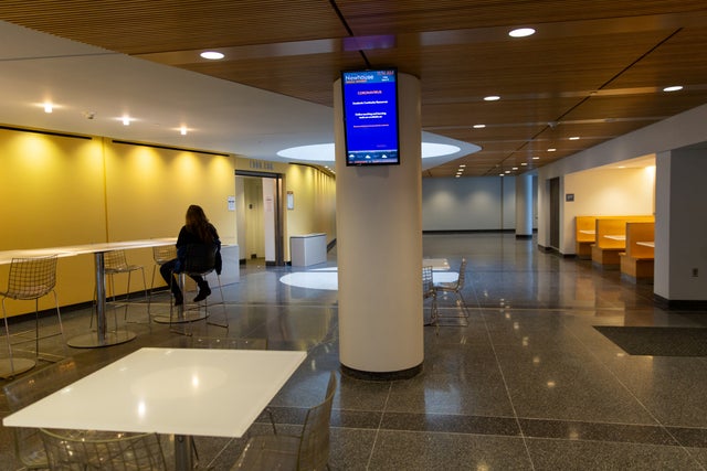 A person sits in an empty eating hall