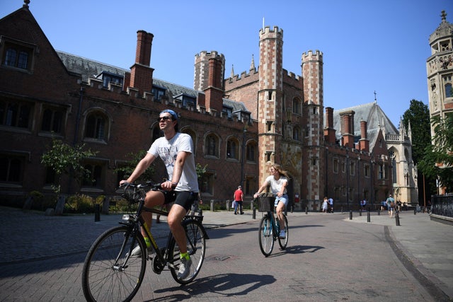 People cycle through Cambridge as the heatwave continues in Britain