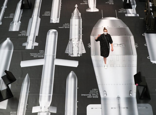 A member of staff stands on Ai Weiwei's 'History of Bombs' during a photocall for the Chinese artist's new work on display at the Imperial War Museum in London