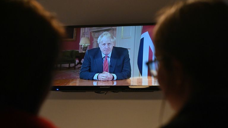 Members of a family watch as Britain's Prime Minister Boris Johnson addresses the nation about the latest updates on the novel coronavirus COVID-19 restrictions, on their television in their home in Liverpool on September 22, 2020. - Britain on Tuesday tightened restrictions to stem a surge of coronavirus cases, ordering pubs to close early and advising people go back to working from home to prevent a second national lockdown.