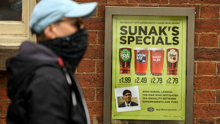 A man walks past a pub advertising 'Sunak's Specials' promotion on beer, referencing the Chancellor of the Exchequer Rishi Sunak in Manchester on August 30, 2020 