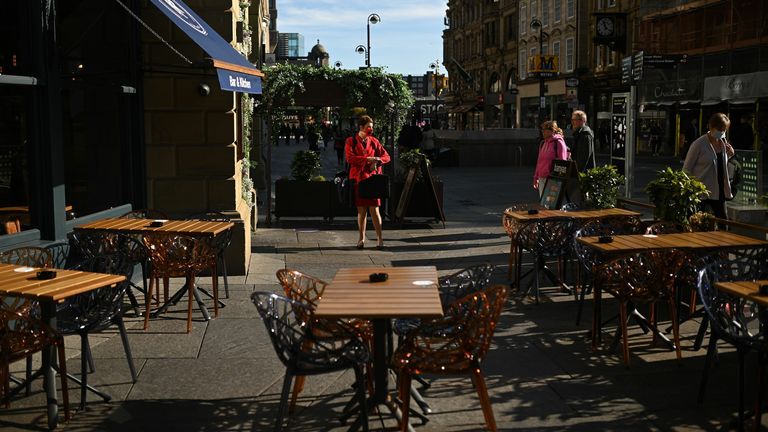 Customers pass empty outside tables 