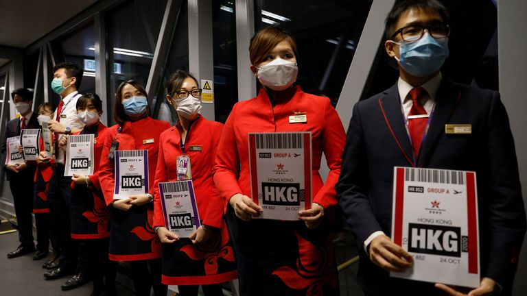 Ground crews hold signs to greet passengers as they come back from the Hong Kong Airline's Embrace "Home" Kong "flight to nowhere" experience, at Hong Kong International Airport, following the coronavirus disease (COVID-19) outbreak, in Hong Kong, China October 24 2020. REUTERS/Tyrone Siu