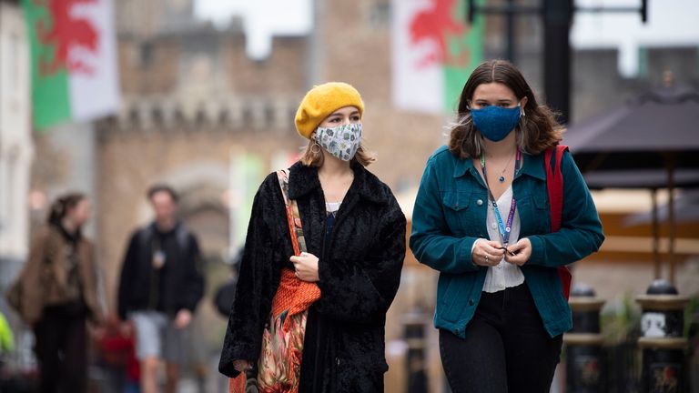 Two women wear face masks as they walk down St Mary Street near Cardiff Castle 