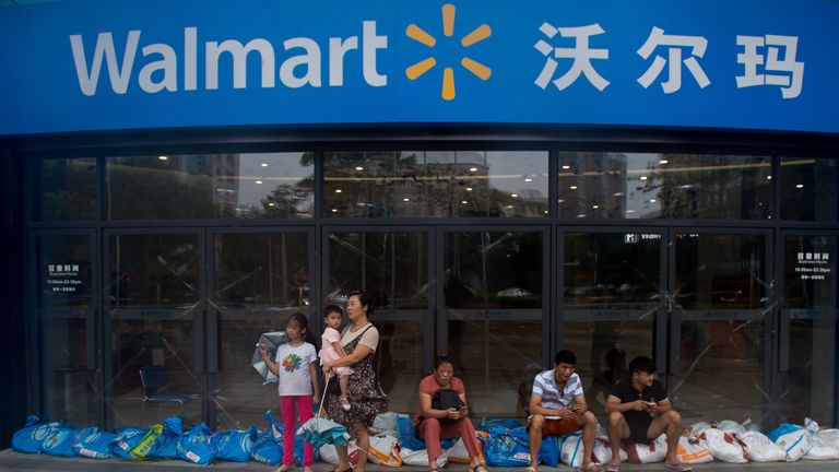 People stranded by heavy rain fall take shelter outside a Walmart ahead of the arrival of Super Typhoon Mangkhut in Yangjiang in China's Guangdong province on September 16, 2018